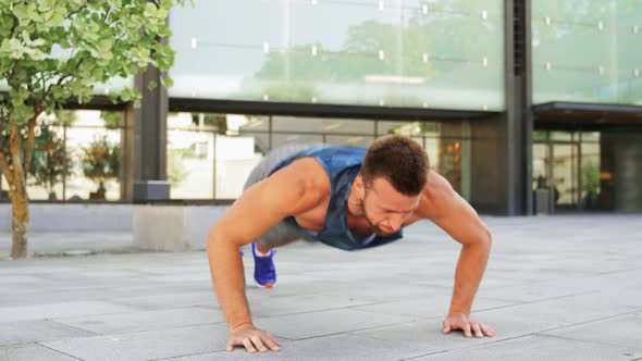 Young Man Doing Push Ups on City Street