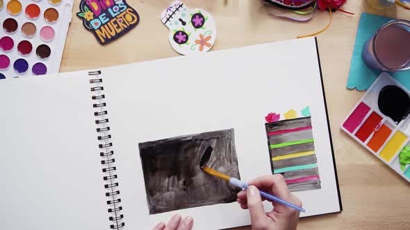 Step by step. Flat lay. Baker sketching a design of a cake with watercolors for Dia de los Muertos h