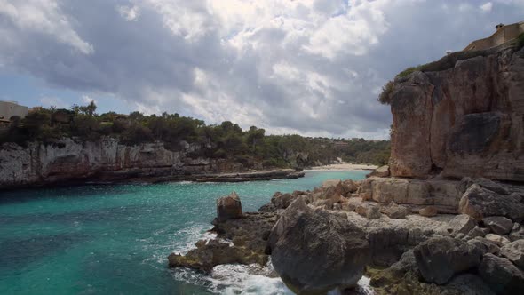 Flying along the Majorcan  coast and through the rocky entrance to a secluded  beach