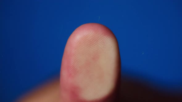 Human Hand Making Thumb Fingerprint on Blue Background