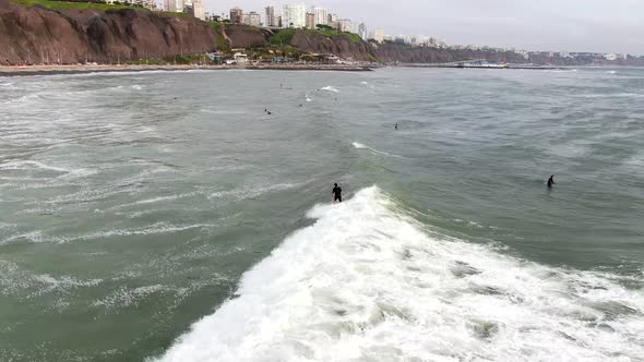 4k daytime aerial video following a surfer riding a wave on the coastal waters of the Pacific Ocean