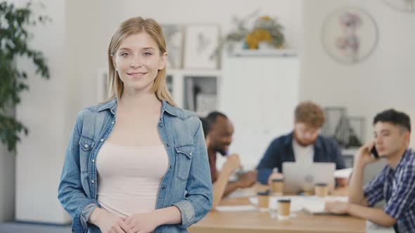 Portrait of Young Blondes Business Woman Looking at Camera and Smiling in Office Workplace