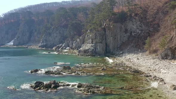 Aerial View of the Rocky Seashore of a Beautiful Bay with Transparent Water