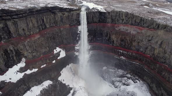 Water crashes down from Hengifoss falls into the frozen basaltic ravine below