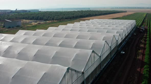 Aerial footage of large greenhouse farm in a green valley