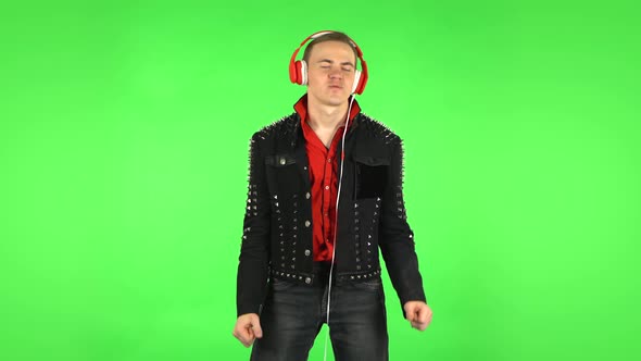 Guy Dancing and Enjoys Music in Big Red Headphones. Green Screen