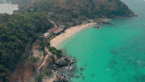 Sandy Coastline with Green Forests and Brown Building Roofs