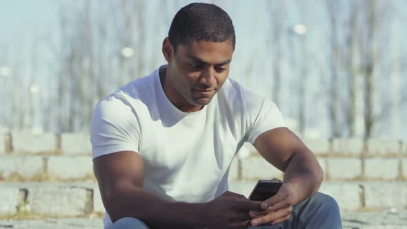 Smiling African American Man Holding Smartphone