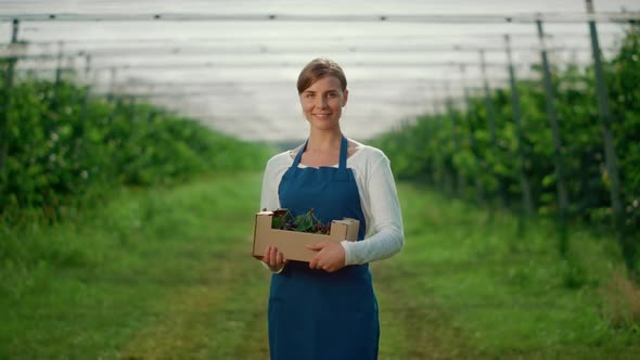 Caucasian Young Woman Holding Berry Box at Fruit Tree Green House