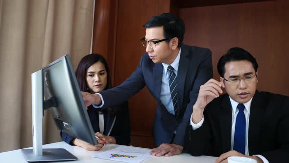 Business people group working together at office desk and checking a financial report.