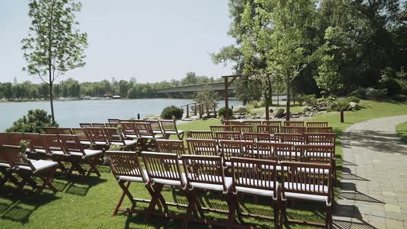 Wedding Arch and Wooden Chairs on the Background Beautiful River Slow Motion