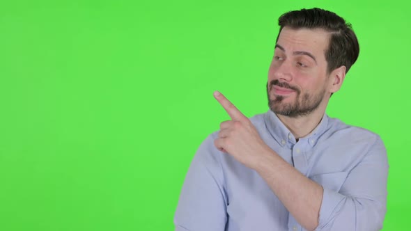 Portrait of Man Pointing Towards Product Green Screen