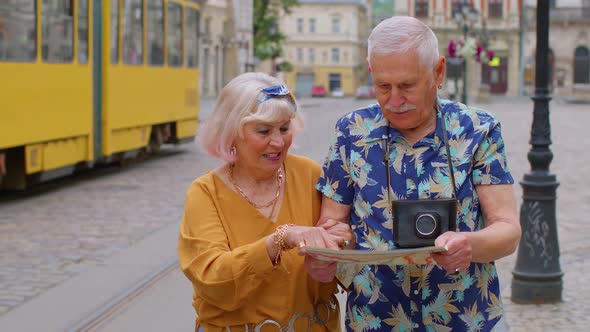 Senior Stylish Tourists Man and Woman Having a Walk and Look for Way Using Paper Map in Old City