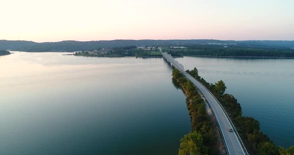 Aerial flight over a bridge and highway that runs through an Ozark lake