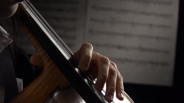 Cello Close Up of Bows Carry on the String with Notes in a Dark Room