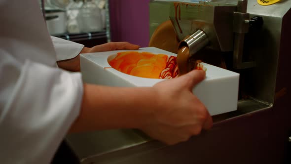 Worker filling mould with melted chocolate