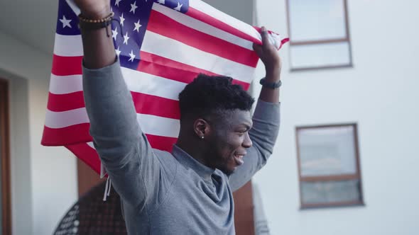 Black Man Waving USA Flag From the Balcony