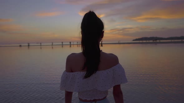 Pretty Asian Woman Walking Alone in the Sea at Beautiful Sunset Thailand
