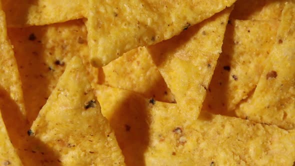 Rotation Macro Nacho Chips Background of Corn Tortilla Chips or Nachos