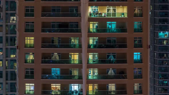 Glowing Windows in Multistory Modern Glass Residential Building Light Up at Night Timelapse