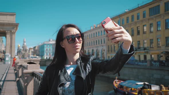 Girl Taking Selfie Portrait on Smartphone in City. Travel and Tourism Concept.