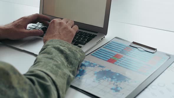 Unrecognizable Army Officer Working on Laptop alt