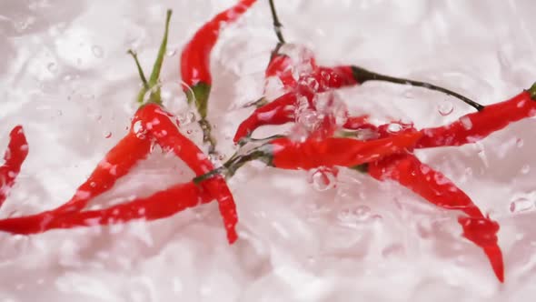 Chili pepper falling on water surface for sanitization.