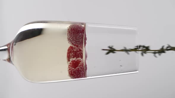 Vertical video, Close-up: strawberries fall into a glass of champagne