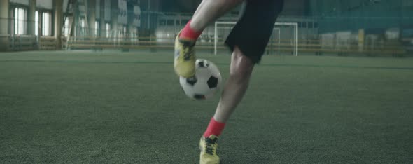 Man Juggling Ball on Indoor Soccer Field