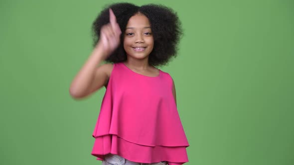 Young Cute African Girl with Afro Hair Pointing Finger Up