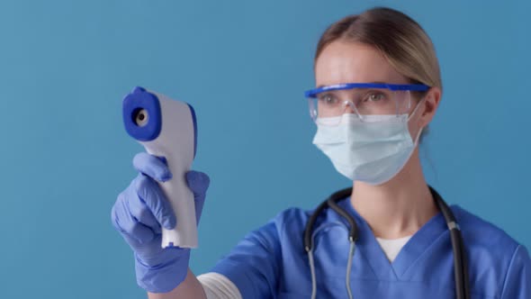 Nurse measures the patient's temperature with non-contact infrared thermometer. Healthcare concept