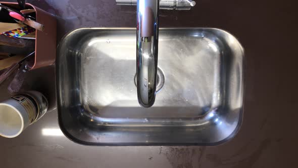 Man washes and prepares hummingbird feeder sequence, shot above the sink view