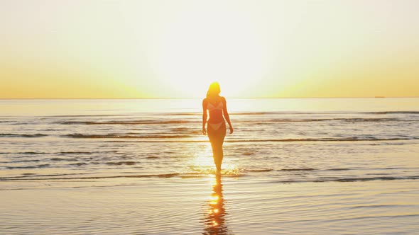 Young Woman in Bikini Swimsuit Running on Beach