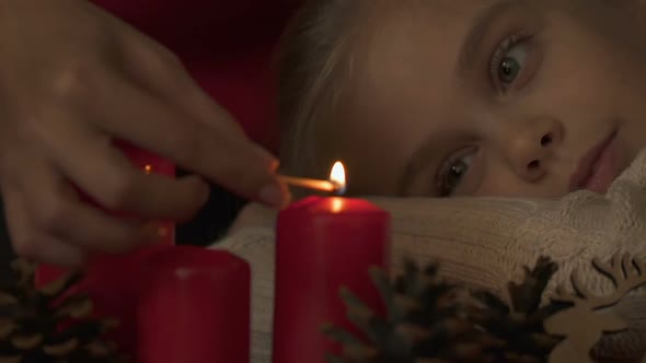 Mother Lighting Candles, Daughter Looking Excitedly, Happy Holidays Together