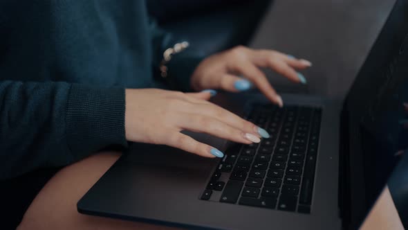 Close Frame in Slow Motion of the Hands of a Businesswoman Typing on the Laptop Keyboard Sitting at