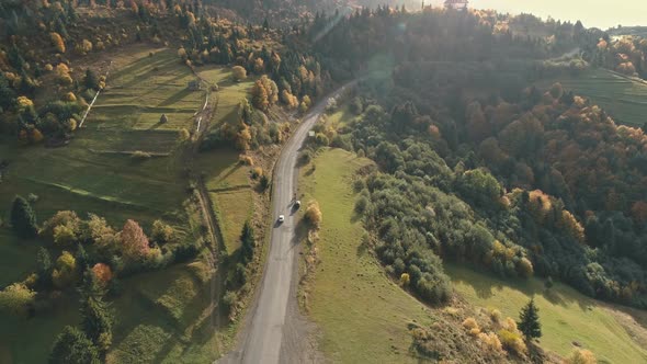 Car Drives Along Grey Winding Asphalt Hilly Road Aerial