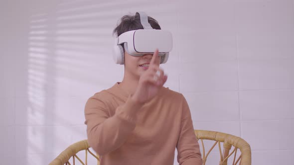 Asian man wearing virtual reality goggles in modern coworking studio.