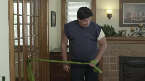 Man using elastic band to exercise his shoulder.