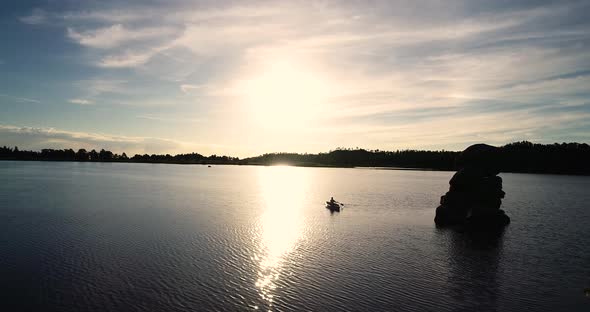 Beautiful Colorado sunrise on a lake with a silhouette of a canoe against the rising sun.  Shot take