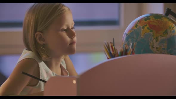 Close-up Face of Blond Caucasian Schoolgirl Writing Down and Searching Something Looking