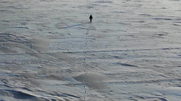 Aerial Top View of a Man with a Backpack Walking By the Tundra.