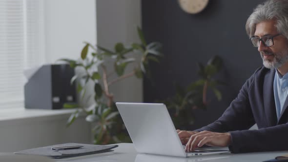 Mid-Aged Businessman Working on Laptop in Office