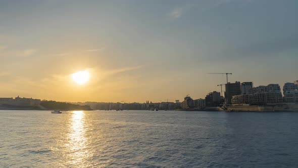 Beautiful Timelapse in Malta overlooking Sliema with boats passing in front of upcoming high rise bu