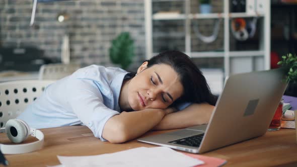 Portrait of Attractive Lady Sleeping at Work on Desk Relaxing During Workday
