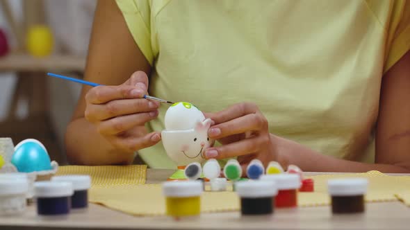 Mom Teaches Her Daughter to Paint Eggs with Paints and Brush