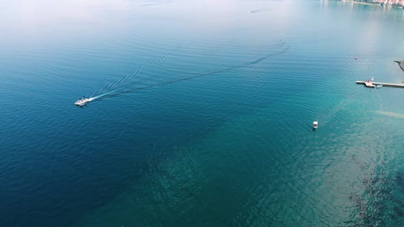 Aerial shot of Macedonia coast and boat on turquoise water around Ohrid Lake in Southern Europe.