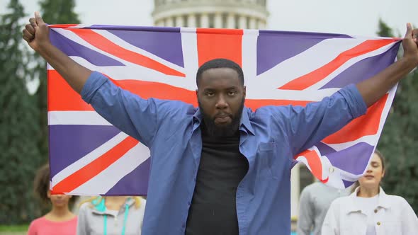 Angry Black Man Raising Great Britain Flag, Brexit Protest, Migration Crisis