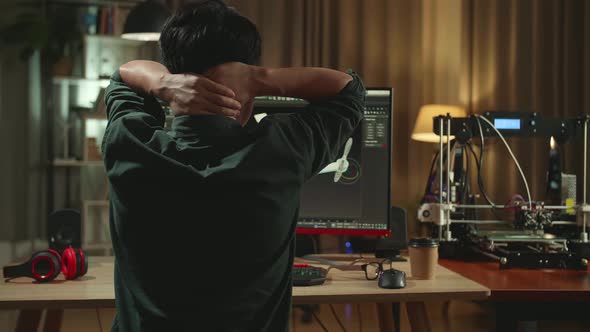 Back View Of Frustrated Asian Engineer Working On Personal Computer And 3D Printer