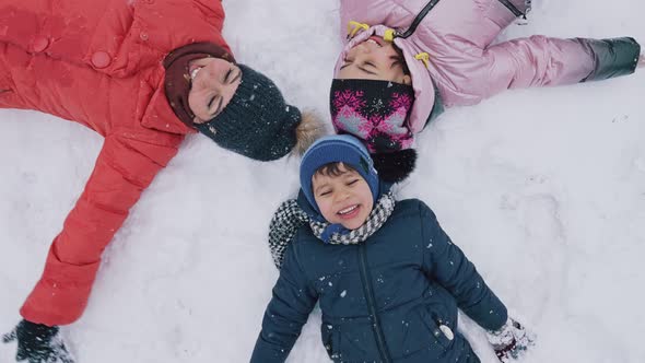 Kids Making a Snow Angel Lying on the Snow