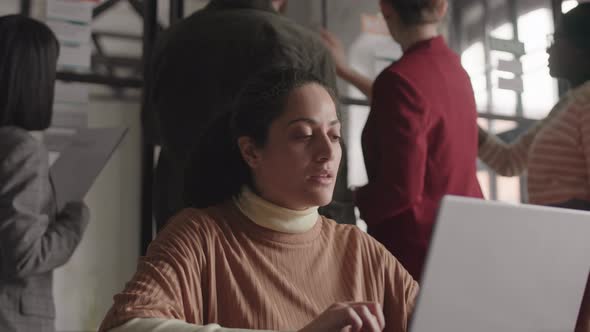 Mixed-Race Woman Using Laptop in Office